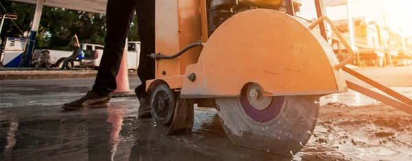 Walk-behind floor saw cutting a concrete slab