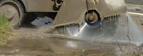 Floor saw wet cutting concrete with water to control dust