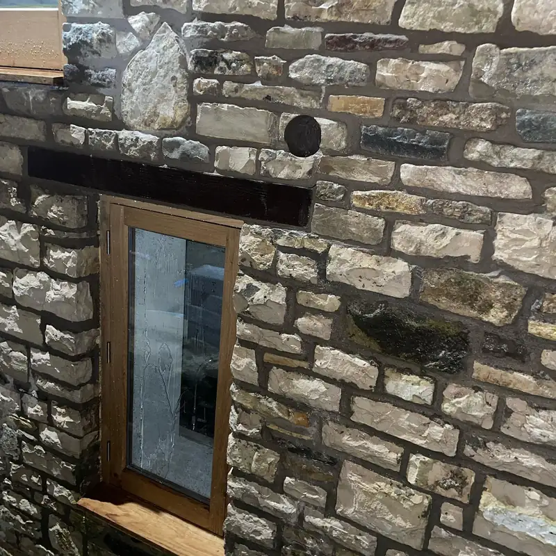 Clean core-drilled hole through a natural stone wall at Bitton railway station