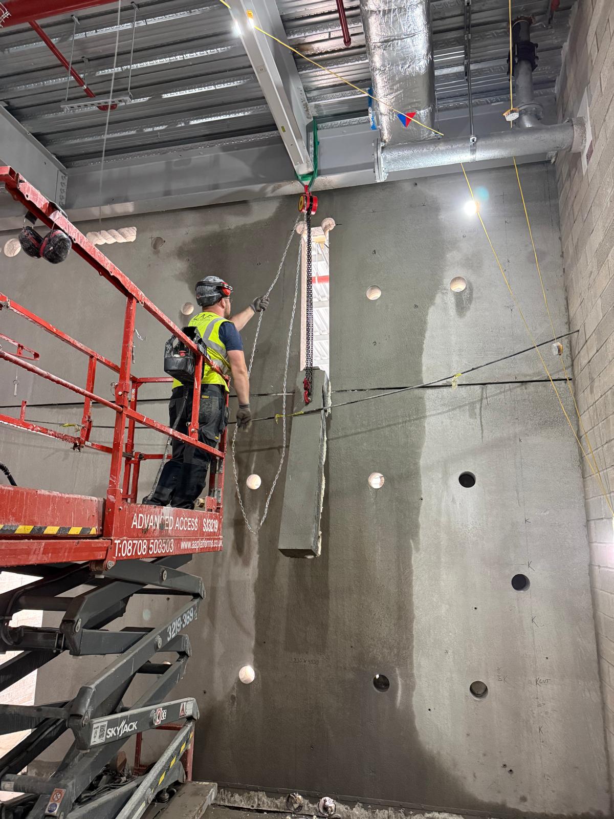 Liam Palmer core drilling a row of 300mm holes through a reinforced concrete wall for a Skanska project