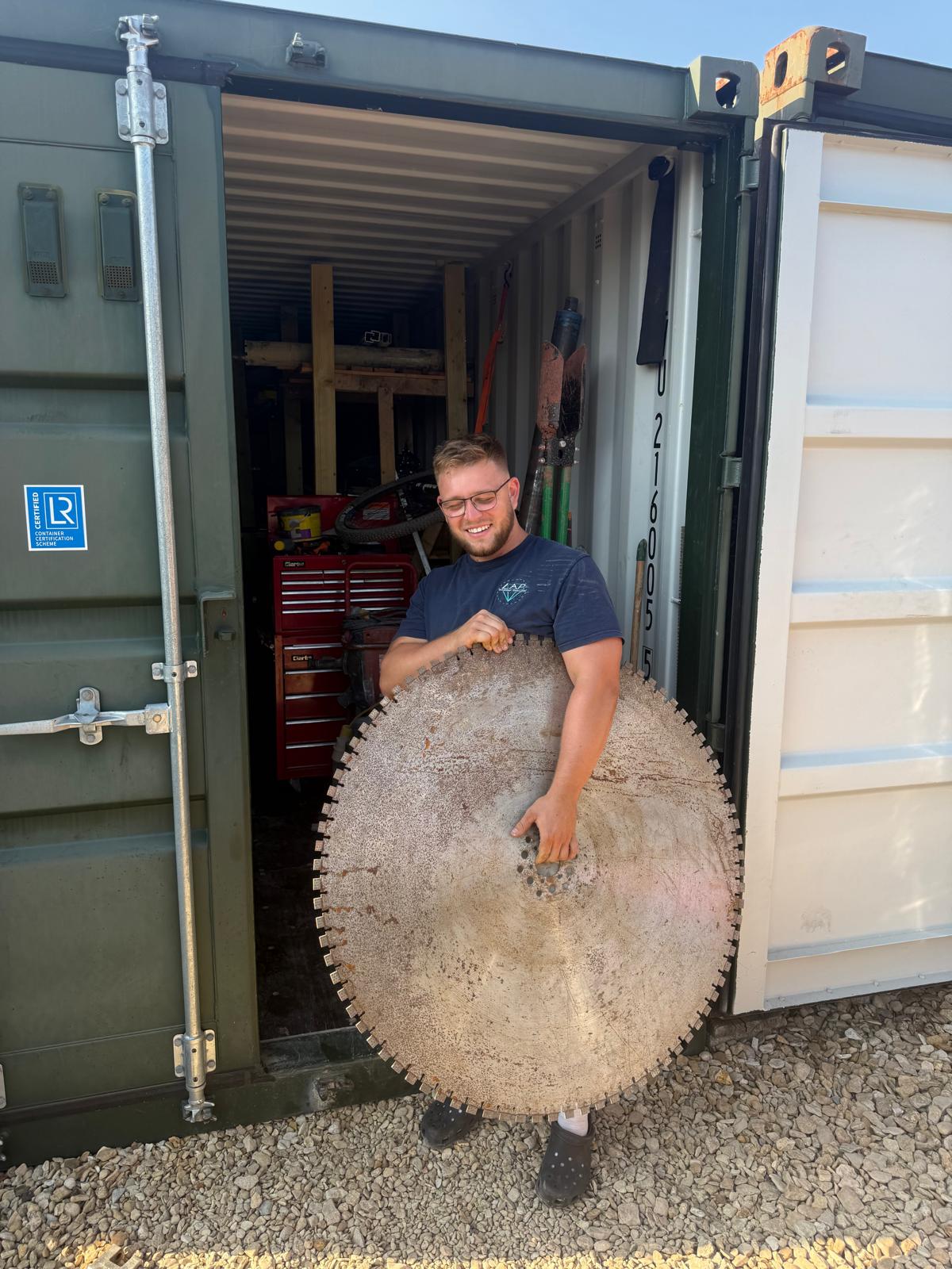 Liam Palmer holding a large concrete core removed from a wall